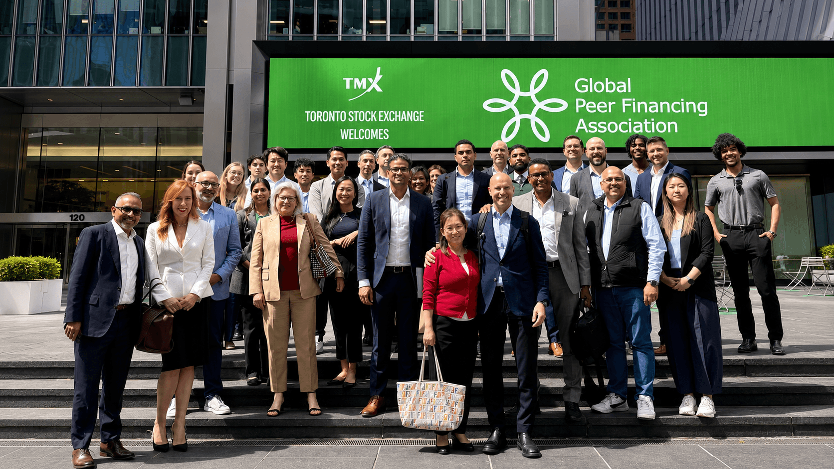 Members of the Global Peer Financing Association gathered on the steps of the Toronto Stock Exchange, whose marquee welcomes the association.